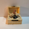 Single miniature vase nestled in a decorated wooden trunk.