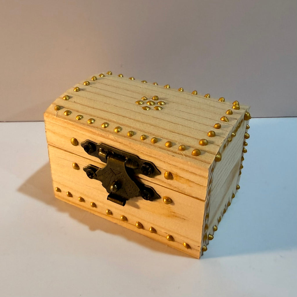 Single miniature vase nestled in a decorated wooden trunk.